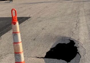 Photo of Wal-Mart workers tape off what onlookers describe as a “small sinkhole” Monday